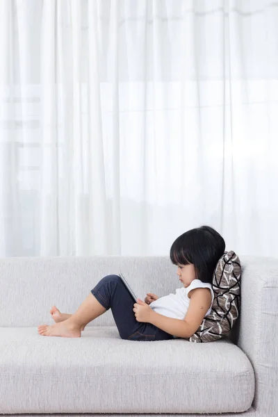 Китайський мало Підлітка пару лежить на дивані з планшета — стокове фото