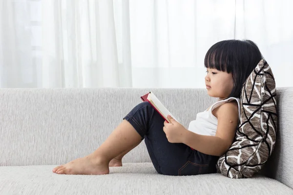 Asiatisch chinesisch klein mädchen reading buch auf die sofa — Stockfoto