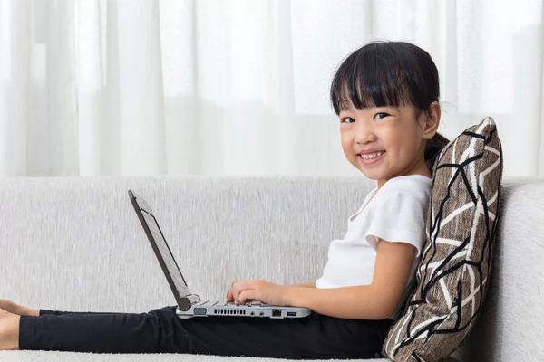 Feliz asiática china niña acostada en el sofá con ordenador portátil — Foto de Stock