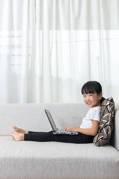 Feliz asiática china niña acostada en el sofá con ordenador portátil — Foto de Stock