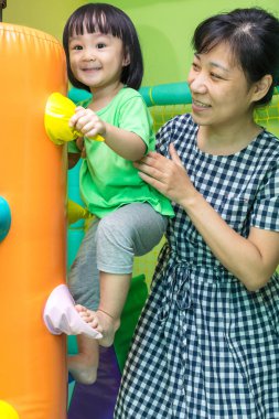 Asya Çin anne ve kapalı parkında oynayan kız