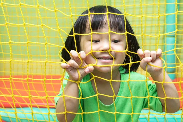 Feliz asiática china niña jugando detrás de la red — Foto de Stock