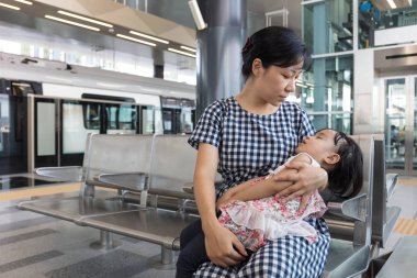 Asya Çin anne Mrt sta içinde taşıma uyuyan kızı