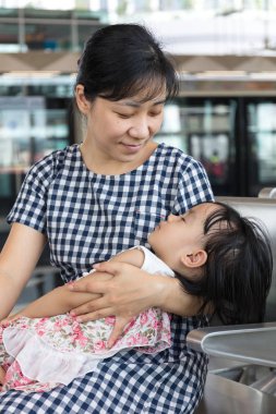Asya Çin anne Mrt sta içinde taşıma uyuyan kızı