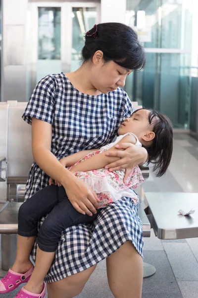 Asiatique chinois mère portant sommeil fille dans un MRT sta — Photo
