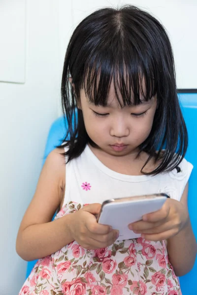 Asiática china niña sentada dentro de un MRT con teléfono — Foto de Stock