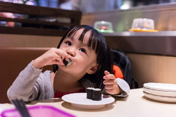 Asiatiska kinesiska lilla flicka äter sushi på en japansk restaurang — Stockfoto