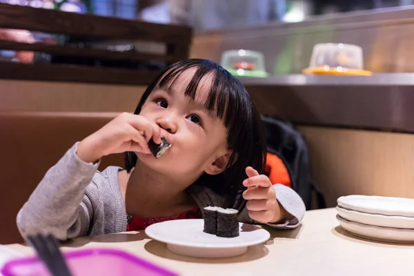Asyalı Çinli küçük kız suşi Japon bir restoranda yemek