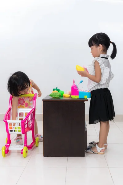 Asiático chino poco hermanas fingiendo cliente y cajero ingenio — Foto de Stock