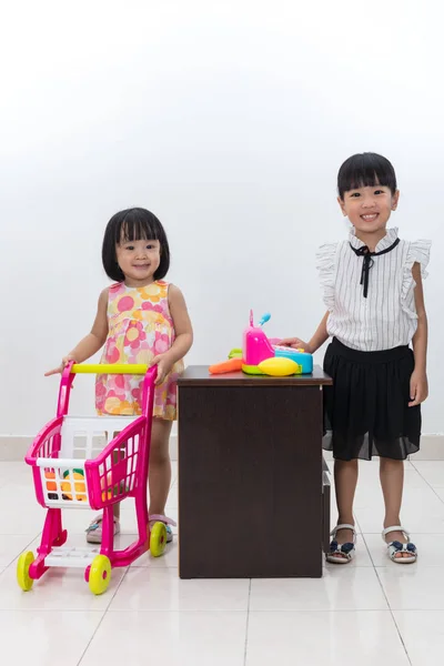 Asiatiska kinesiska små systrar låtsas kund och kassören wit — Stockfoto