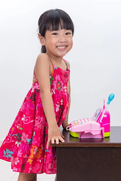 Menina chinesa asiática feliz fingindo como caixa com brinquedos — Fotografia de Stock