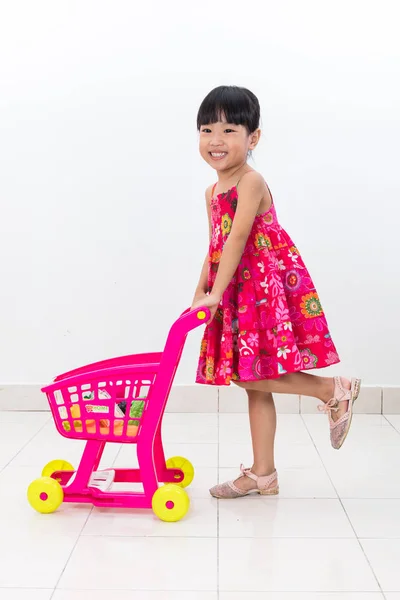 Feliz asiático chino niña empujando juguete carro — Foto de Stock