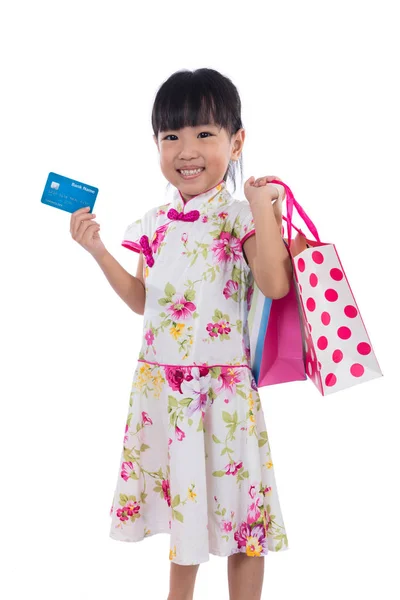 Asiatisk kinesisk lille pige iført cheongsam holder indkøbspose - Stock-foto