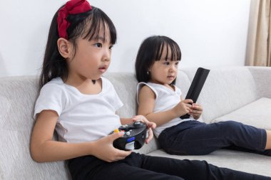 Asyalı Çinli küçük kız Tv kanepede oyun