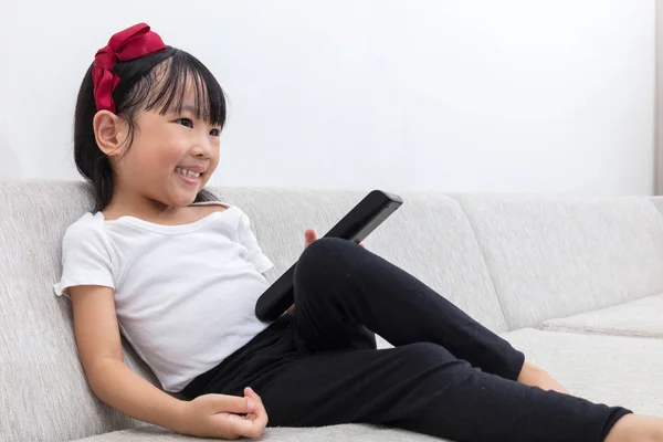 Gelukkig Aziatische Chinese meisje houdt van een Tv-afstandsbediening — Stockfoto