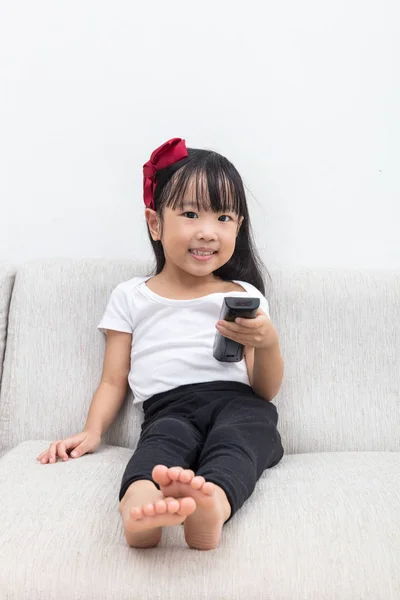 Feliz asiática china niña sosteniendo un televisor control remoto — Foto de Stock