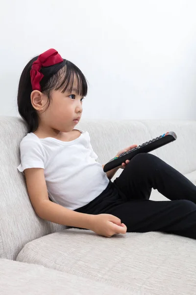 Asiático chinês menina segurando um controle remoto de TV — Fotografia de Stock