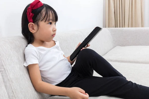 Asiática china niña sosteniendo un televisor control remoto — Foto de Stock