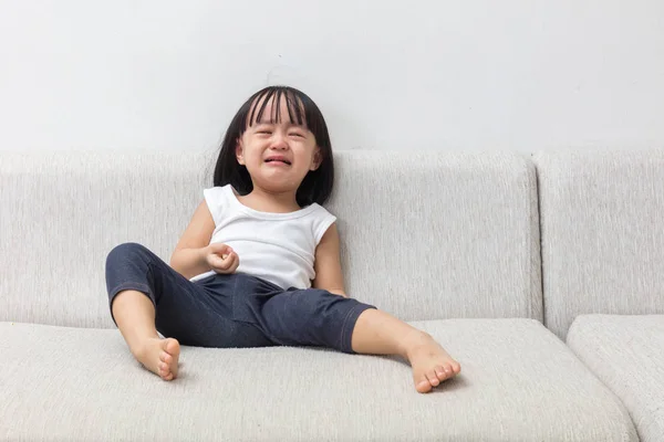 Asijská Čínská holčička sedí na pohovce pláč — Stock fotografie