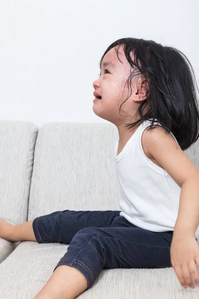 Азіатський китайський маленька дівчинка, сидячи на дивані плакала — стокове фото