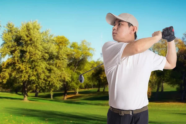 Lächelnd asiatisch chinesisch mann swinging golf club — Stockfoto