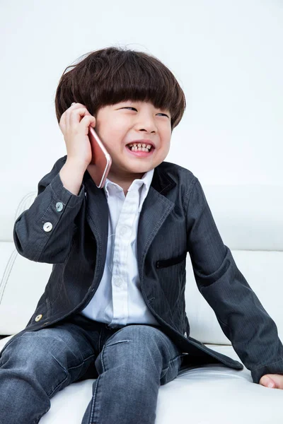 Asijská Čínská malý chlapec sedí na gauči s smartphone — Stock fotografie