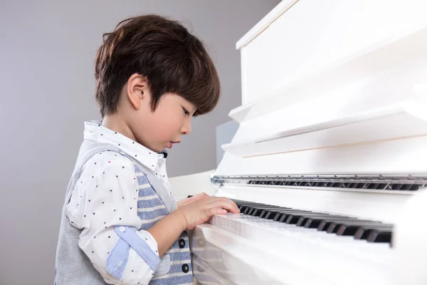 Asiático chino pequeño niño jugando piano en casa —  Fotos de Stock