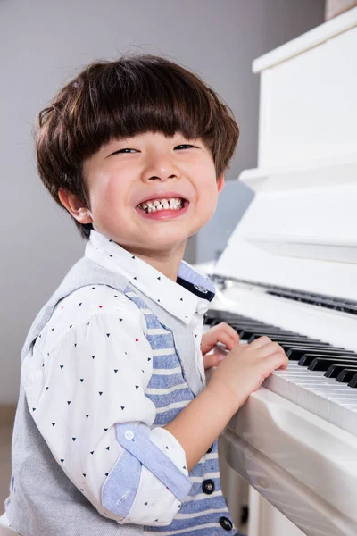Szczęśliwy azjatycki chiński chłopiec trochę gry na fortepianie w domu — Zdjęcie stockowe
