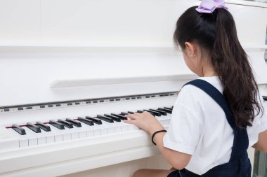 Asyalı Çinli küçük kız evde klasik piyano