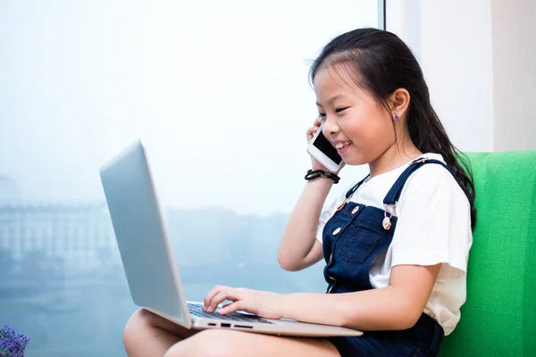 Azjatycki chiński dziewczynka rozmawia przez telefon z laptopem — Zdjęcie stockowe