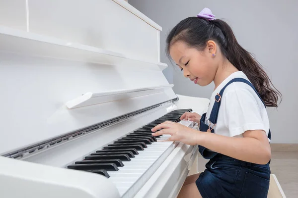 Szczęśliwy azjatycki chiński dziewczynka grający klasyczny fortepian w domu — Zdjęcie stockowe