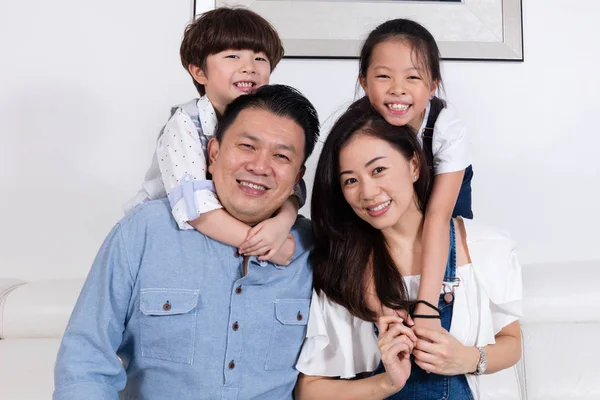 Щасливі азіатських китайські родини, сидячи на дивані посміхаючись — стокове фото