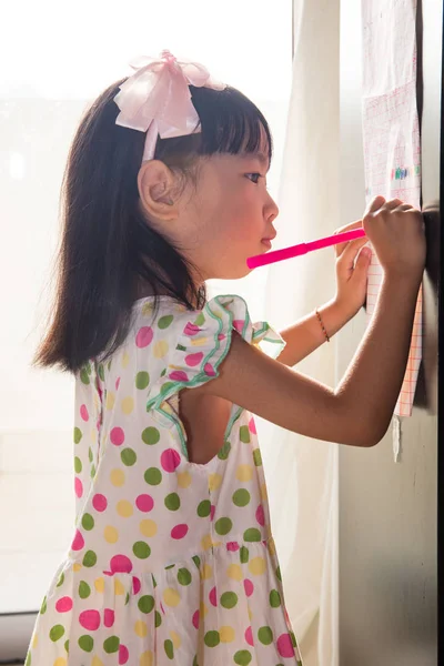 Asijská Čínská holčička psaní na papír s zpět osvětlení — Stock fotografie