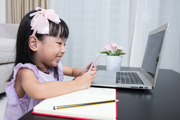 Asiática china niña ocupada leyendo teléfono móvil y portátil — Foto de Stock