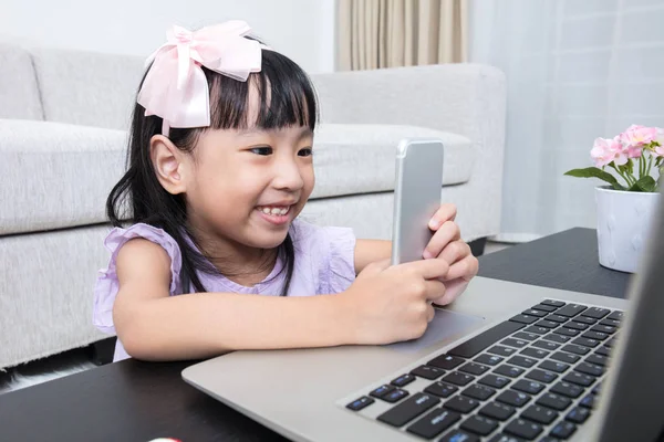 Asiática china niña ocupada leyendo teléfono móvil y portátil — Foto de Stock