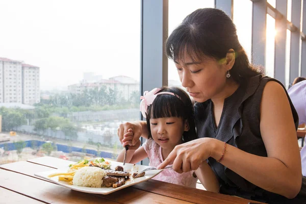 Asian Chinese mother and daughter eating steak — Stock Photo, Image
