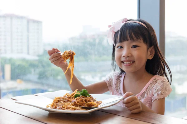 Asyalı Çinli küçük kız spagetti bolognese yeme