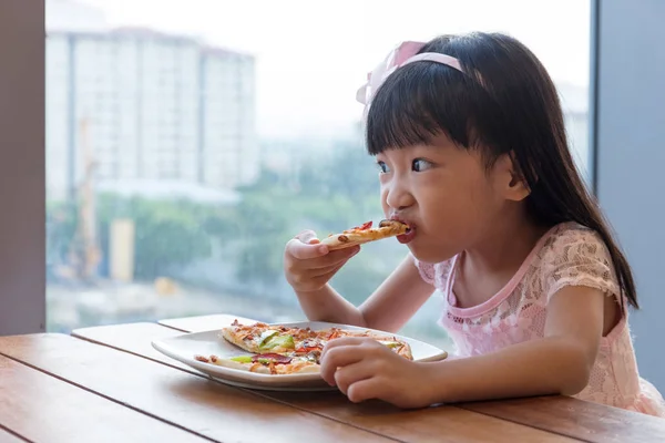 Asiatiska kinesiska lilla flicka äter pizza pepperoni — Stockfoto