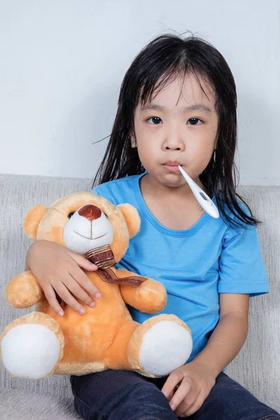 Ασιατικές κορίτσι κινεζική κρατώντας αρκουδάκι για πυρετό θερμοκρασία ΠΠΣ — Φωτογραφία Αρχείου