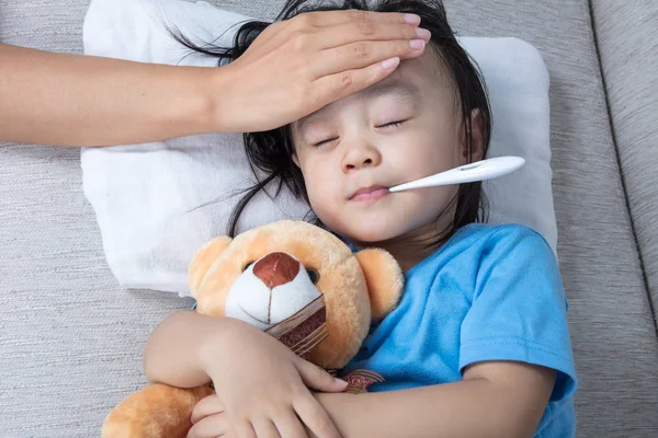 Azjatycki chiński matka pomiarowych trochę czoło dziewczynka gorączka — Zdjęcie stockowe