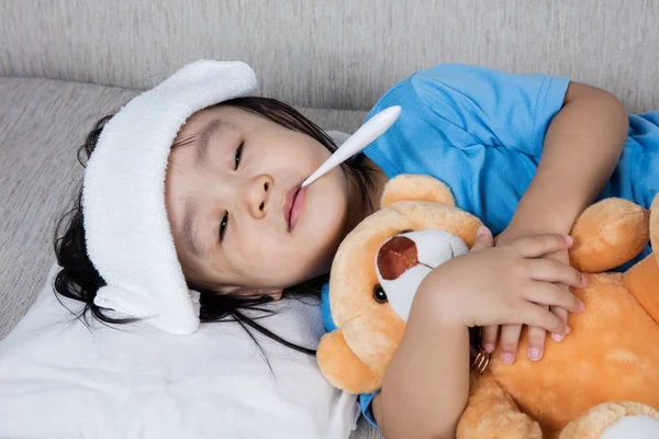 Asiático chino chica holding teddy oso para fiebre temperatura meas — Foto de Stock