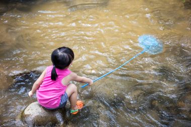Asyalı Çinli küçük kız Balık ağı ile balık yakalamak