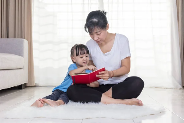 Aziatische Chinese moeder en dochter lezen op de verdieping — Stockfoto