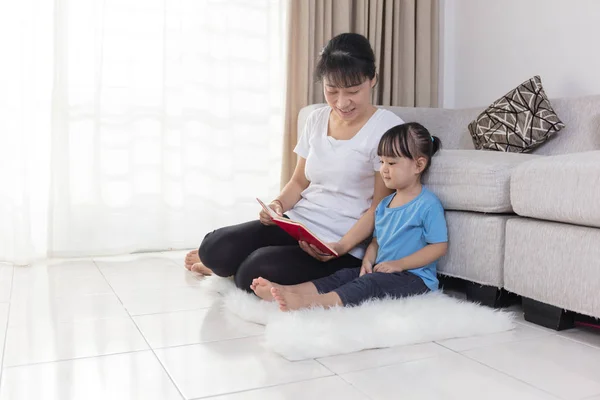Азіатський китайський мати і дочка, читання на поверсі — стокове фото