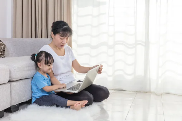 Gelukkig Aziatische Chinese moeder en dochter met behulp van laptop thuis — Stockfoto