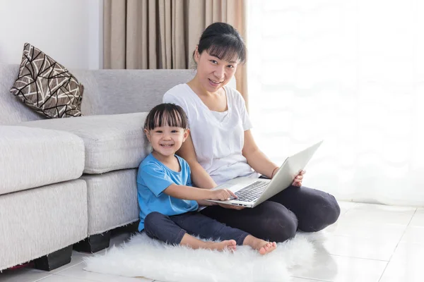 Gelukkig Aziatische Chinese moeder en dochter met behulp van laptop thuis — Stockfoto