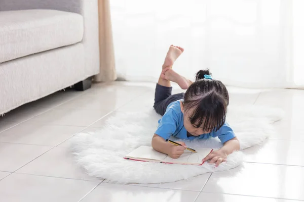 Asijská Čínská holčička leží na podlaze, kreslení — Stock fotografie