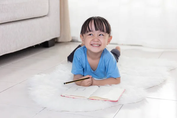 図面に床に横たわって幸せアジア中国小さな女の子 — ストック写真