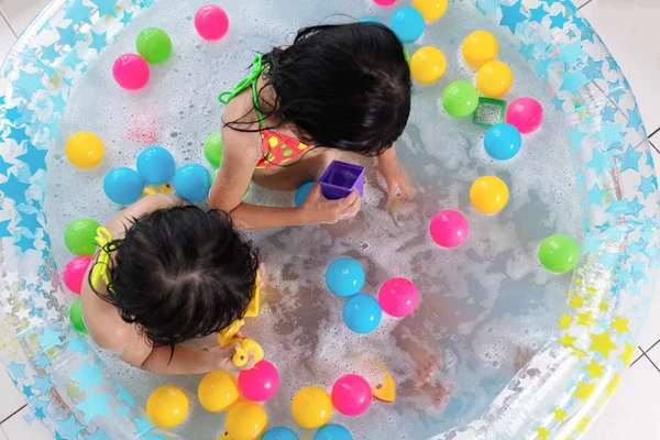 Asyalı Çinli küçük kız şişme havuzda oynarken — Stok fotoğraf
