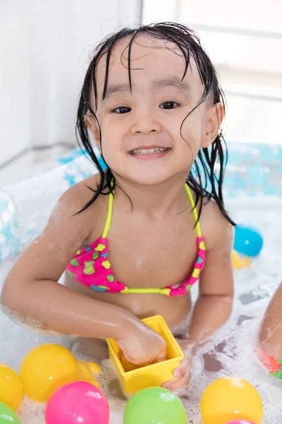 Felice asiatica bambina cinese che gioca nella piscina gonfiabile — Foto Stock